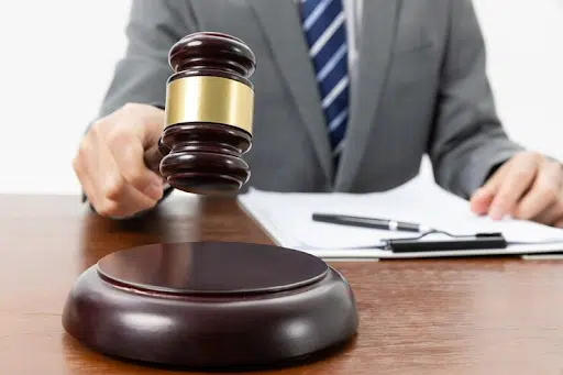 A judge holding the gavel on top of his desk.