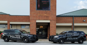 Austell City Hall with two Austell Police SUVs parked in front.